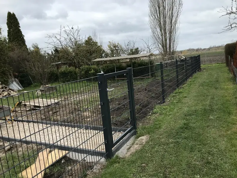 Doppelstabmattenzaun mit Gartenpforte an einem frisch angelegten Beet